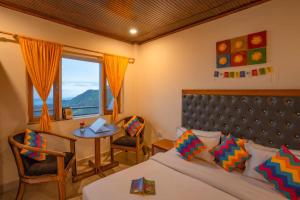 a bedroom with a bed and a table and a window at goSTOPS Mussoorie, Library Road in Mussoorie