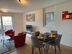 een woonkamer met een eettafel en stoelen bij Deux pas du lac & Centre de Montreux in Veytaux