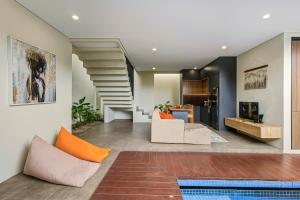 un salon avec un escalier et un canapé dans l'établissement JK Bhavana Villas, à Ngemplak