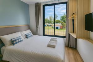 Un dormitorio con una cama grande con ventana. en Sea Side at Ao Nang Landmark Night Market Krabi, en Ban Khlong Haeng