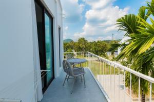 Un balcón con dos sillas y una mesa. en Sea Side at Ao Nang Landmark Night Market Krabi, en Ban Khlong Haeng