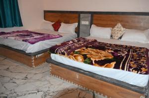 two beds sitting next to each other in a bedroom at Malwa resort in Chitrakoot