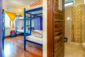 a room with two bunk beds and a bathroom at goSTOPS Mussoorie, Library Road in Mussoorie