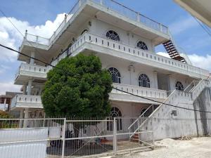 een wit gebouw met een boom ervoor bij Gedung Putih Syariah in Palas 2