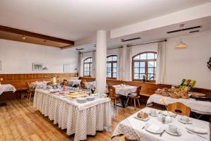 ein Esszimmer mit Tischen und weißen Tischdecken in der Unterkunft Garni Hotel Kessler in Dorf Tirol
