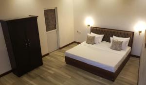 een slaapkamer met een groot bed en een kast bij Floating Castle Villa in Avissawella