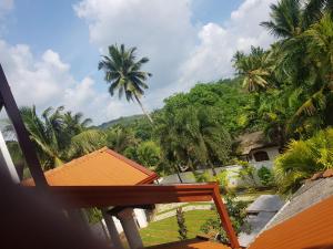 uitzicht vanaf het balkon van een resort met palmbomen bij Floating Castle Villa in Avissawella