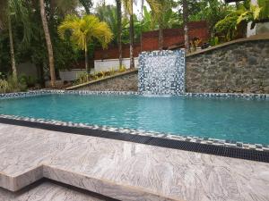 een zwembad met een fontein bij Floating Castle Villa in Avissawella