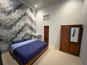 een slaapkamer met een bed en een stenen muur bij Gedung Putih Syariah in Palas 2