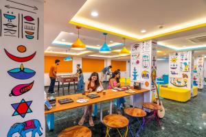 a group of people sitting at a table in a room at goSTOPS Mussoorie, Library Road in Mussoorie