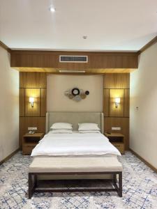 ein Schlafzimmer mit einem großen weißen Bett mit zwei Tischen in der Unterkunft Vella Elegant Hotel in Andijon