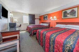 a hotel room with two beds and a television at Knights Inn Ferguson MO in Castle Point