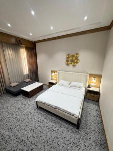 ein Hotelzimmer mit 2 Betten und 2 Tischen in der Unterkunft Vella Elegant Hotel in Andijon