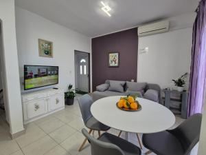 a living room with a table and chairs and a tv at Relax in Preko