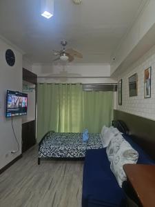 大雅台Jewels Staycation at Cityland Tagaytay Prime Residences的一间卧室，里面有一张床和一台平板电视 更多40张照片