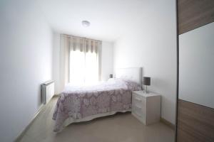 um quarto branco com uma cama e uma janela em Apartamento centro histórico en Manresa em Manresa