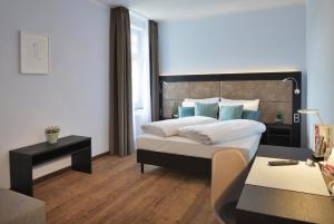 a bedroom with a large bed and a table at UHU Gästehaus Superior in Cologne