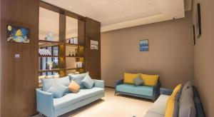 a living room with a couch and two chairs at Borrman Hotel Nanning Railway Station in Nanning