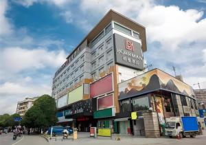 a building with a sign on the side of it at Borrman Hotel Nanning Railway Station in Nanning