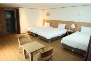 a hotel room with two beds and a table at Hotel Rest Seogwipo in Seogwipo +94 photos