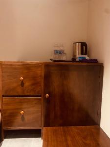 a wooden cabinet with a coffee maker on top of it at Châu Home in Ninh Binh