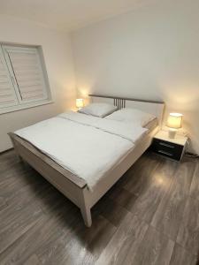 a bedroom with a large white bed with two lamps at Apartmány Pavlík in Františkovy Lázně +12 photos