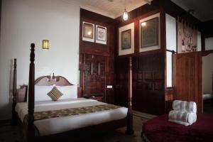 een slaapkamer met een bed en een stoel bij By The Bay Kovalam in Trivandrum +30 foto's