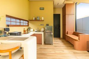 a kitchen with yellow walls and wooden floors at Bale Marva, Gianyar - Modern Tropical Hideaway near Ubud & Bali Safari Park in Lebih