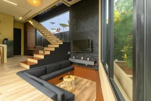 a living room with a couch and a staircase at Bale Marva, Gianyar - Modern Tropical Hideaway near Ubud & Bali Safari Park in Lebih