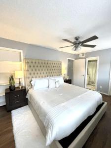 a bedroom with a large white bed with a ceiling fan at 1BD Condo HWY161-183 DFW South Irving - I67 in Sowers