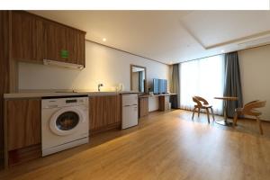 a kitchen with a washing machine in a room at Hotel Rest Seogwipo in Seogwipo