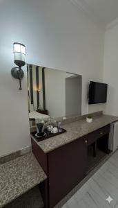 Habitación de hotel con tocador y espejo en Makran Palace Hotel, en Ma‘ābīlah