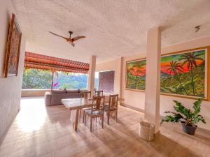 a living room with a table and chairs and a couch at Made Punia's Hidden Jungle Ubud in Ubud