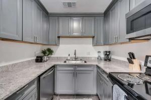 eine Küche mit weißen Schränken und einer Spüle in der Unterkunft 1BD Condo HWY161-183 DFW South Irving I65 in Sowers