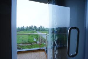 a room with a balcony with a view at Hampi Palace in Hampi