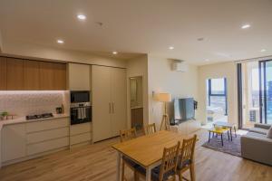 Una cocina y una sala de estar con mesa y sillas. en The Sirius in the central of CBD, en Adelaida