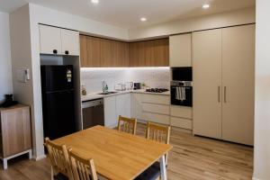 cocina con mesa de madera y nevera negra en The Sirius in the central of CBD, en Adelaida