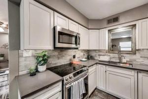 a kitchen with white cabinets and a stove top oven at 1BD Condo HWY161-183 DFW South Irving - I63 in Sowers