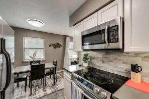 a kitchen with a stove top oven next to a table at 1BD Condo HWY161-183 DFW South Irving - I63 in Sowers