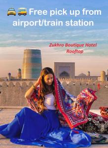 een vrouw zittend op de grond met een deken bij Zukhro Boutique Hotel in Khiva