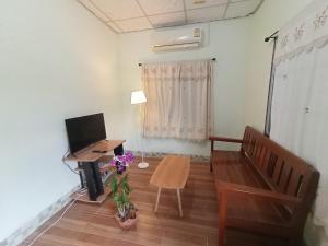 un salon avec une télévision et une table dans l'établissement Future house, à Ban Yang Pa Kha