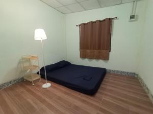 Cette petite chambre comprend un lit bleu et une lampe. dans l'établissement Future house, à Ban Yang Pa Kha