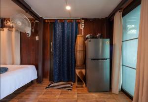 a room with a refrigerator and a bed and a fan at Maya guest house@coffee in Ko Chang