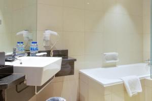 廈門市にあるPark Hotelの洗面台と鏡のある白いバスルーム