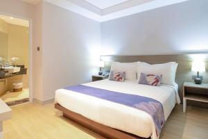 a bedroom with a large bed and a bathroom at Park Hotel in Xiamen