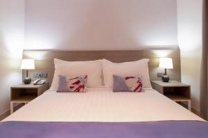 廈門市にあるPark Hotelの大きな白いベッドと2つのランプのある寝室