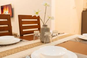 een tafel met borden en een vaas met bloemen erin bij FREEDOM homes in Arusha +11 foto's