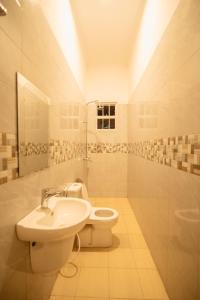 een witte badkamer met een toilet en een wastafel bij FREEDOM homes in Arusha