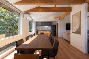 a dining room and kitchen with a long table and chairs at Hakuba Mitsuki Chalet in Hakuba