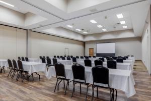 een vergaderzaal met witte tafels en zwarte stoelen bij Comfort Suites Johnson Creek Conference Center in Johnson Creek
